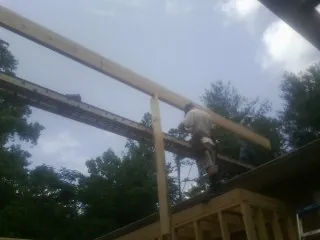 Carpenter setting a ridge beam over a new addition frame — Ice Dam Removal by Roofing Brothers in Pointblank