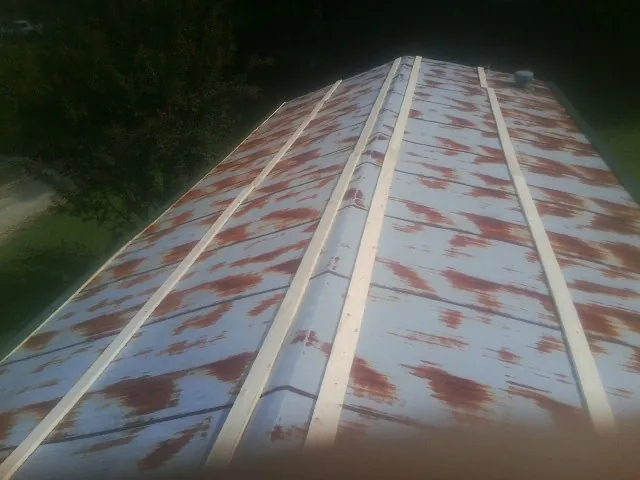 Rusted metal roof panels with new wood purlins before replacement — Storm Damage Roof Repair in Pointblank by Roofing Brothers