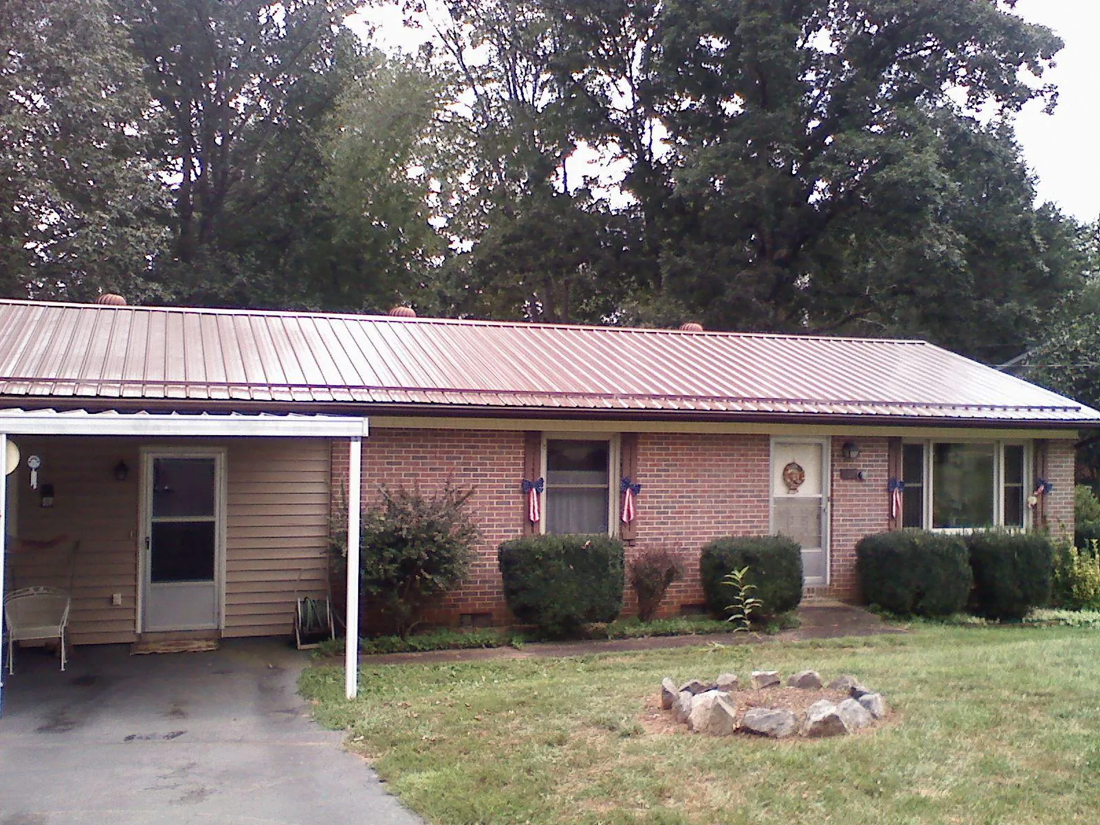 Bronze metal roof and carport on a brick ranch home — Roof Repair work by our crew in Pointblank
