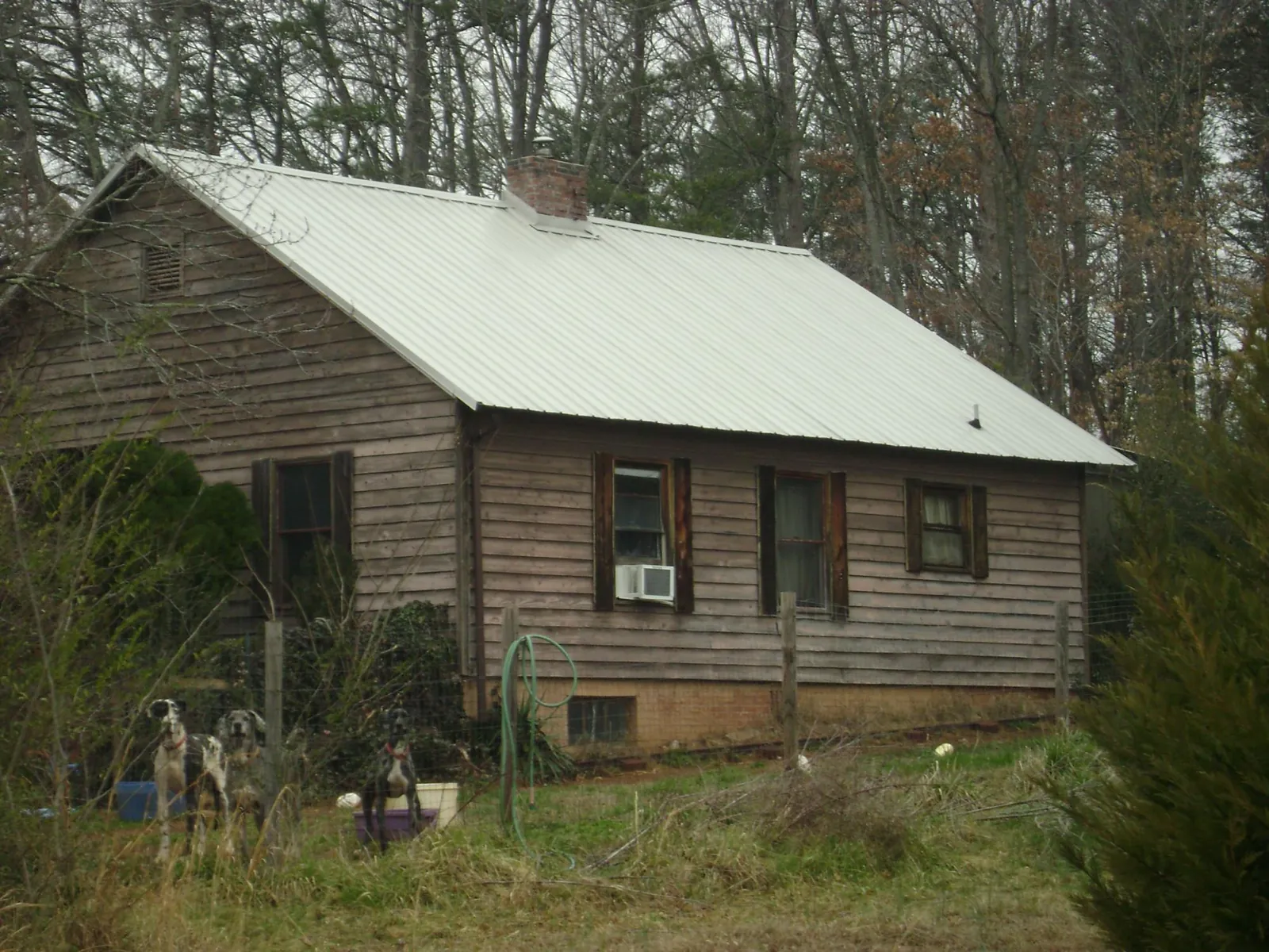 White metal roof on an old wood sided farmhouse, from a Metal Roof Installation job in Pointblank
